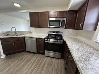 A kitchen with brown cabinets and stainless steel appliances.
